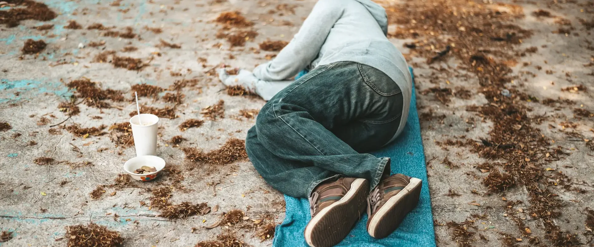 The beggars lay on their side of the street with dirty clothes.